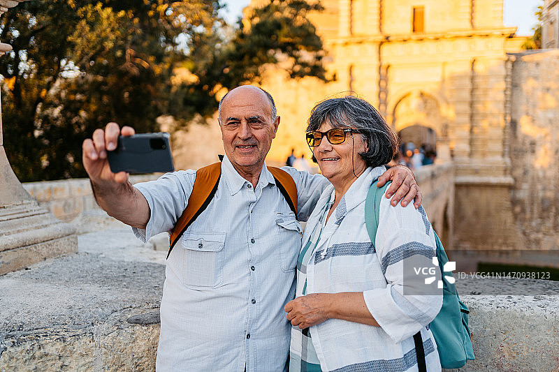 老年游客夫妇在马耳他姆迪纳门前自拍图片素材
