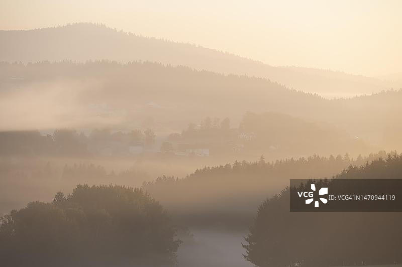 巴伐利亚森林格吕恩巴赫村庄的晨雾森林和山脉，德国巴伐利亚图片素材
