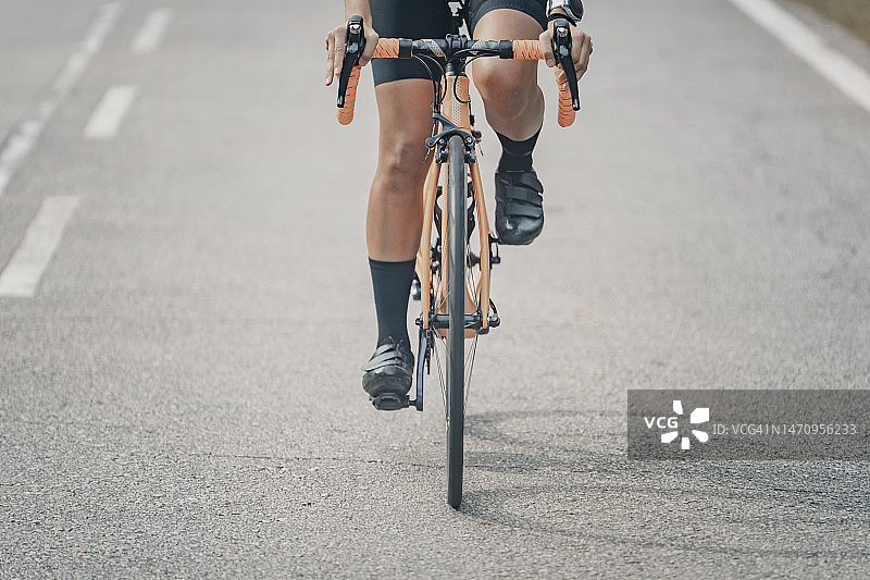 仰视：道路上带阴影的亚洲华人自行车骑行者图片素材
