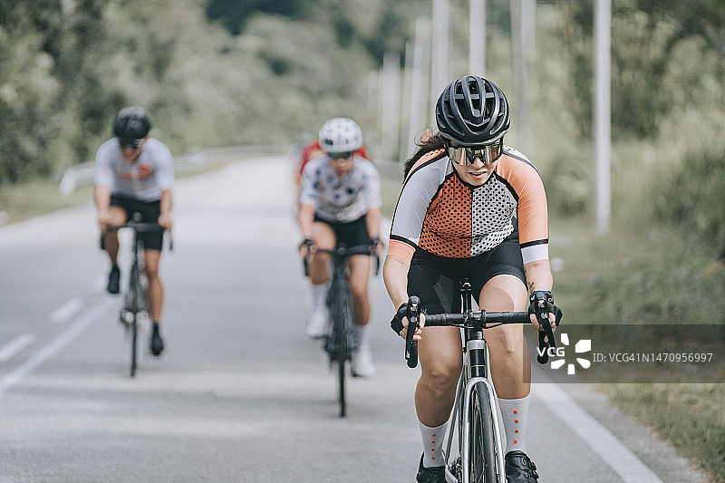 中国亚洲女自行车手在自行车比赛中领先图片素材