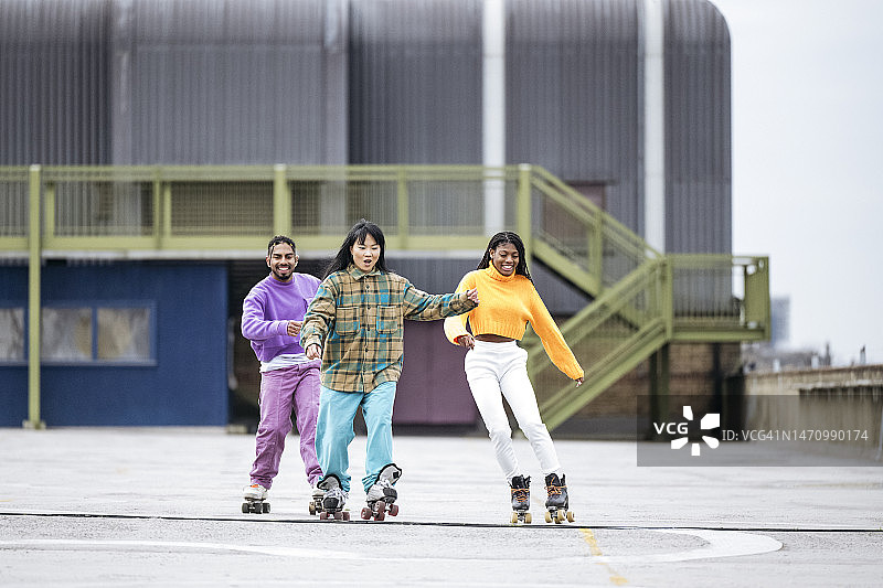 朋友们在水泥屋顶上玩轮滑图片素材