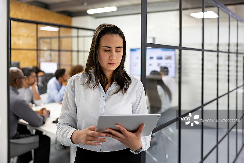 商务女性使用平板电脑离开会议室图片素材