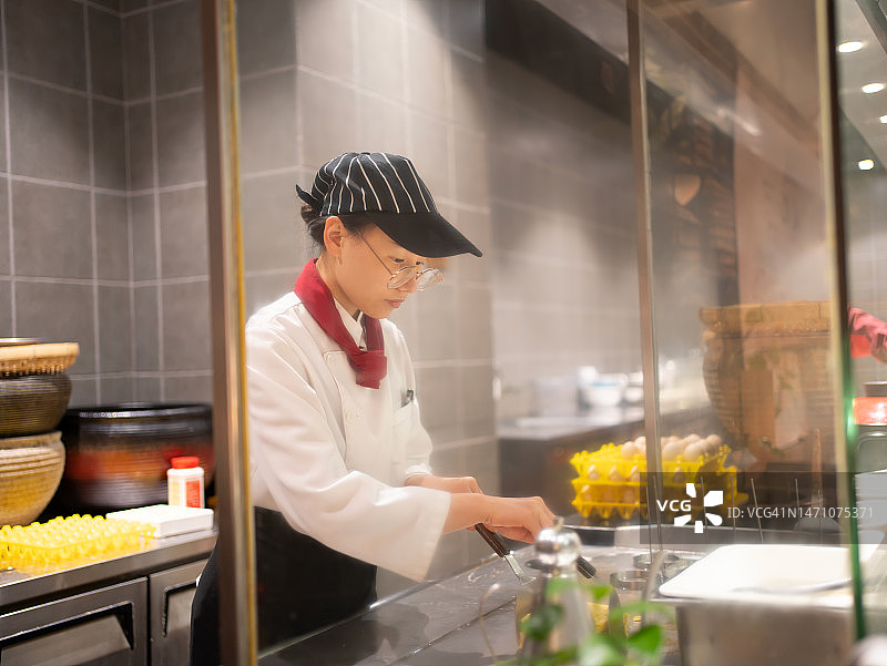 年轻女厨师制作煎蛋卷图片素材