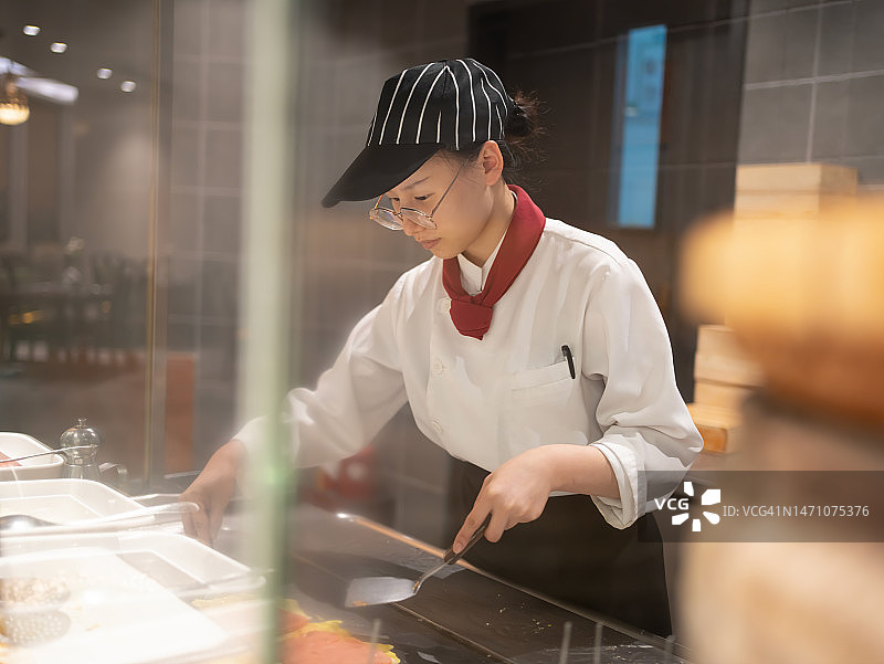 年轻女厨师制作煎蛋卷图片素材