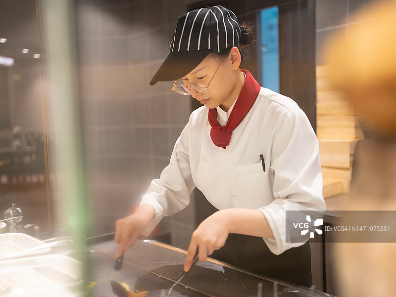 年轻女厨师制作煎蛋卷图片素材