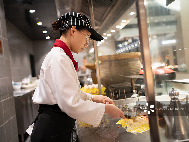 年轻女厨师制作煎蛋卷图片素材