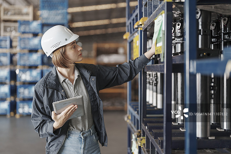 在配送仓库中使用平板电脑的女工图片素材