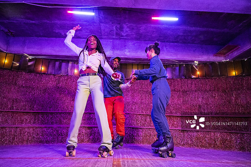 三个年轻的朋友滑旱冰跳舞图片素材