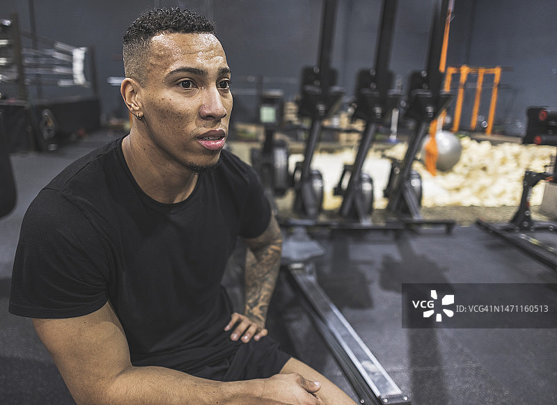 在健身房休息的西班牙裔运动男人，满身是汗图片素材