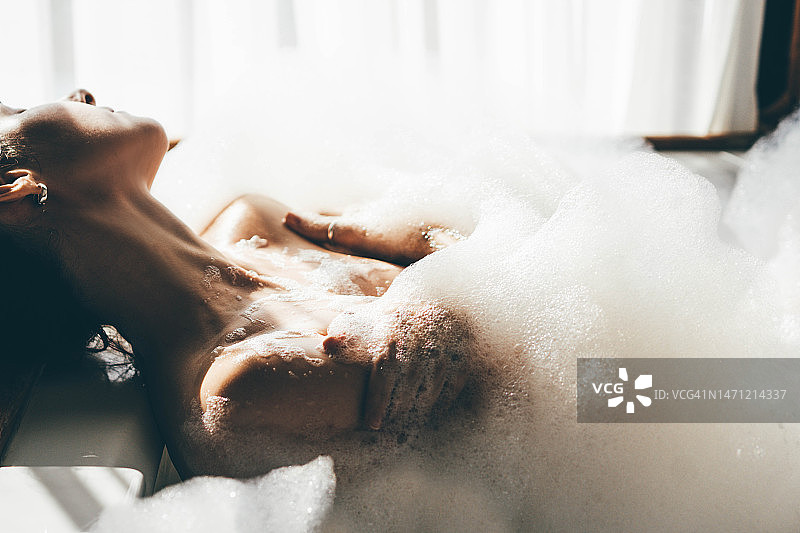 女人在酒店房间的热水浴缸中放松图片素材