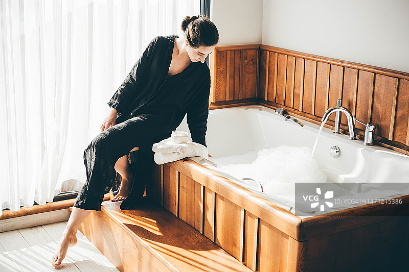 女人在浴室放松，触摸水图片素材