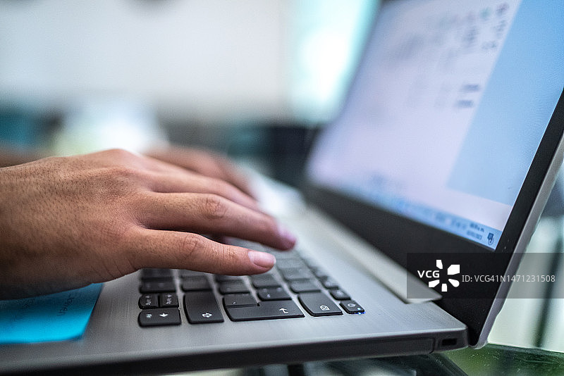 男子在家使用笔记本电脑特写图片素材