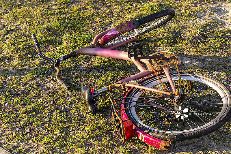 草地上锈迹斑斑的紫色女孩自行车图片素材