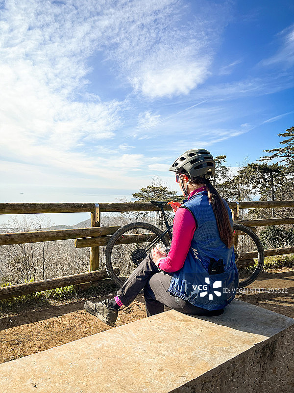 年轻女人休息并欣赏的里雅斯特湾的景色图片素材