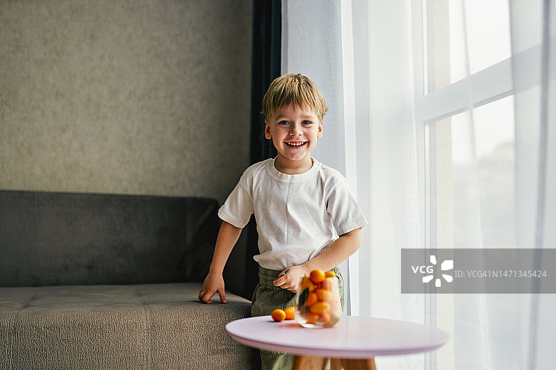 在窗边对着镜头微笑的男孩图片素材