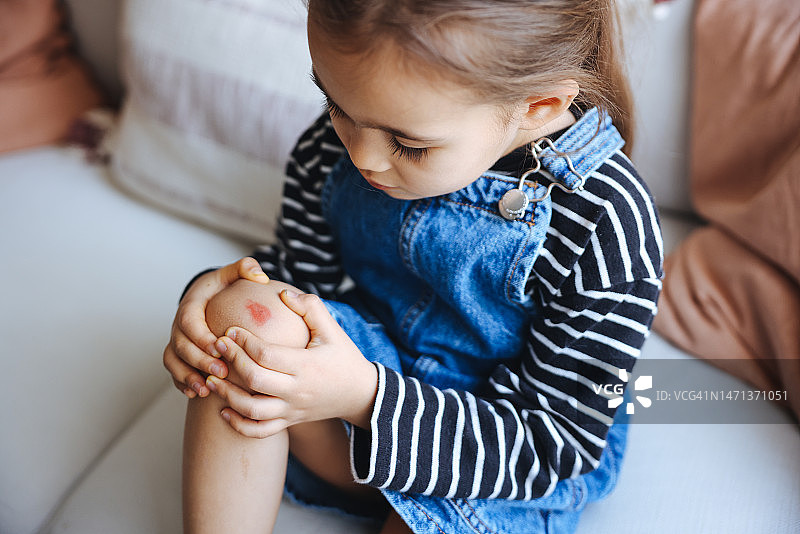 受伤的儿童脚：灰色背景上受伤的膝盖和伤口图片素材