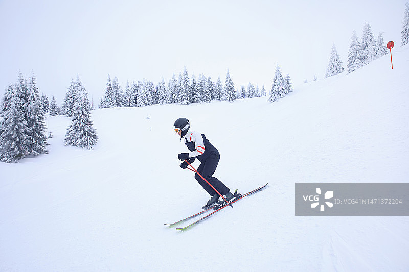 冬季运动：高山滑雪，雪地滑雪者在滑雪胜地滑雪图片素材