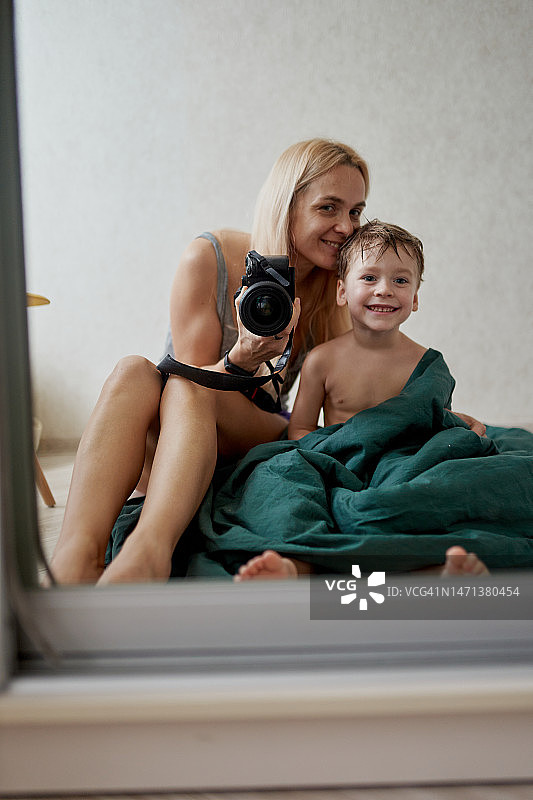 透过镜子看到的妈妈和儿子人像图片素材