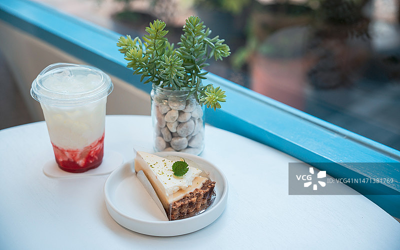 阳光明媚的日子里，白色桌子上放着青柠派和冰镇韩式草莓牛奶图片素材