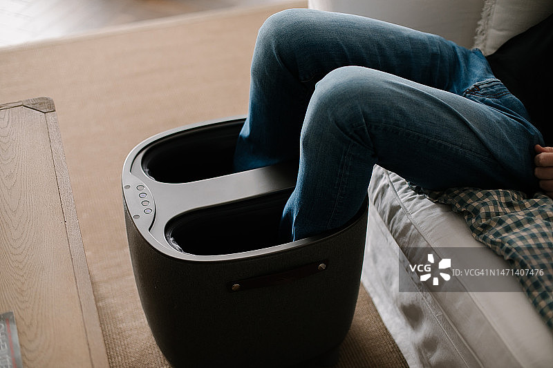 家中沙发旁的舒适电动足部按摩器图片素材