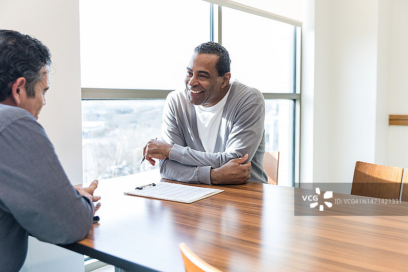 老年男顾问鼓励地对中年男人微笑图片素材