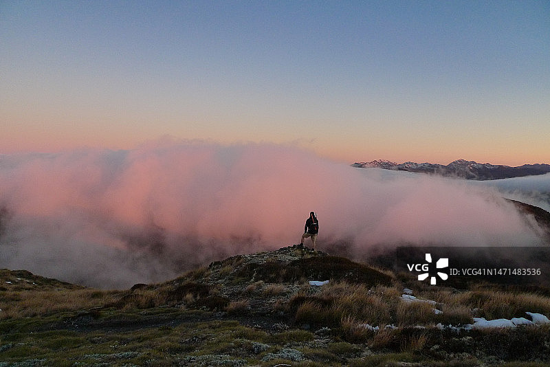 云层之上日出时分的人物剪影 | 新西兰图片素材