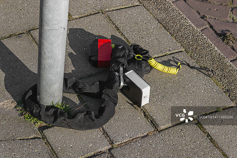 街上金属管上的带安全绳的黑色挂锁图片素材