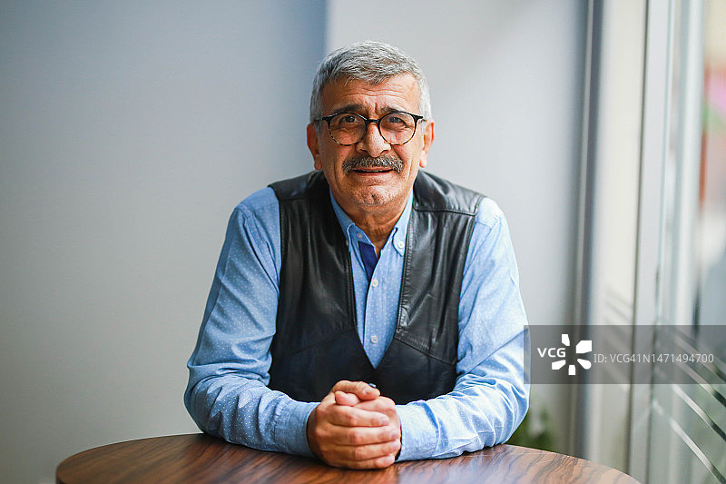 衬衫革履、面带微笑的老年男人室内肖像图片素材