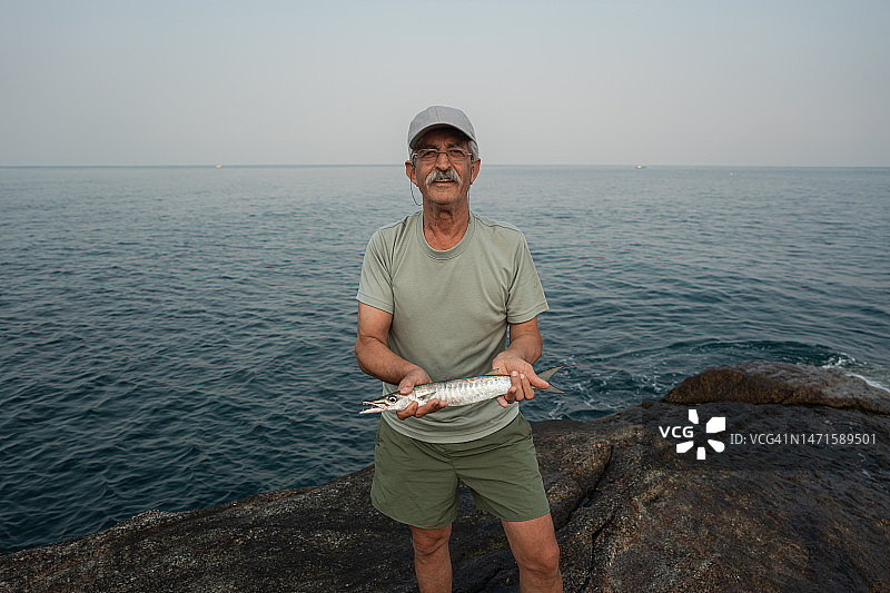 自豪的老渔民和他的战利品图片素材