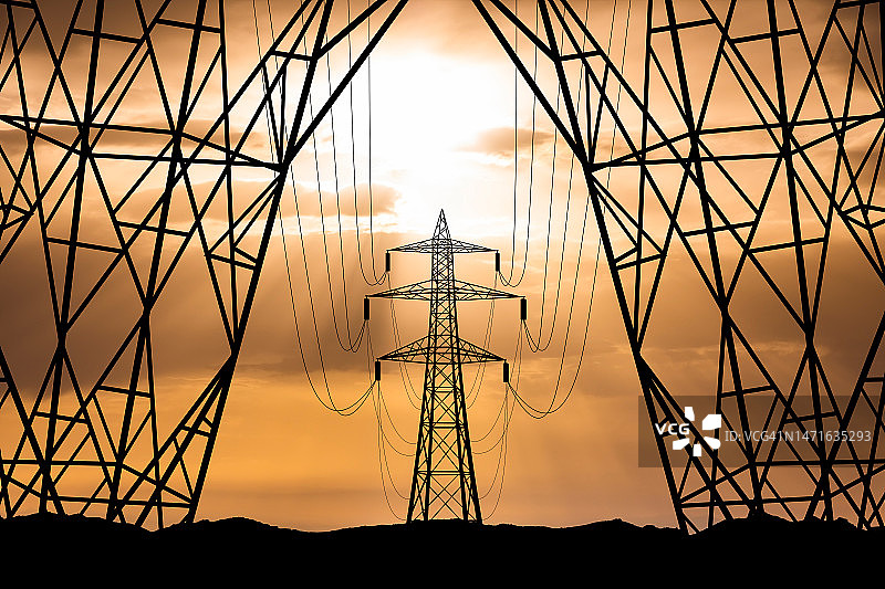 日落背景下的高压塔，天空中的电力线图片素材