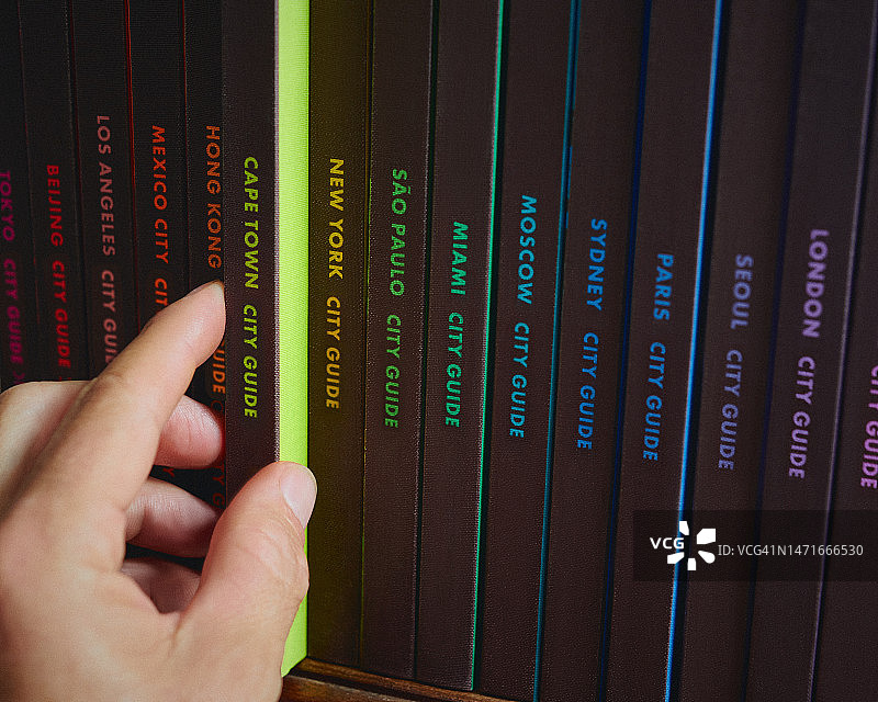 一只手从书架上取下开普敦城市指南图片素材