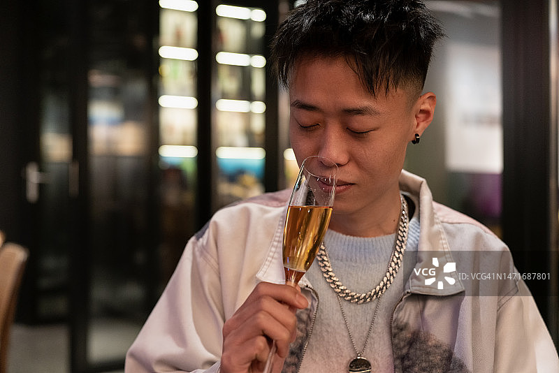 年轻亚洲男子在酒吧喝酒图片素材