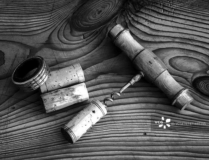 里加松木桌上的旧螺旋开瓶器和一些软木塞图片素材