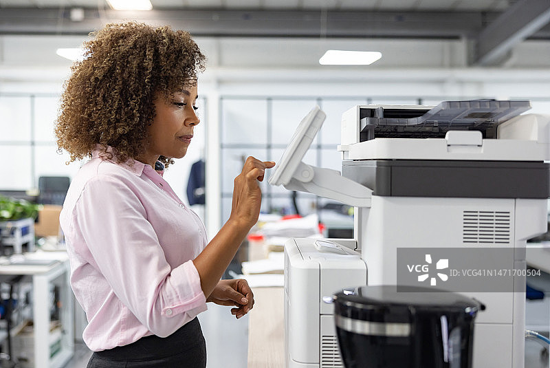 在办公室复印文件的女商人图片素材
