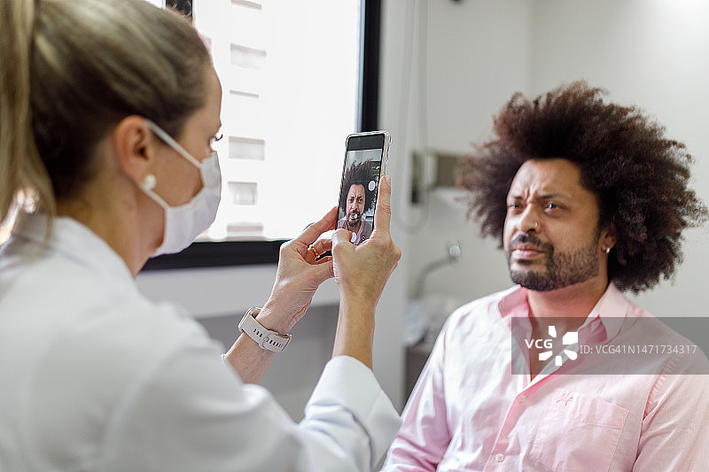 皮肤科医生正在拍摄男士治疗前后的照片图片素材