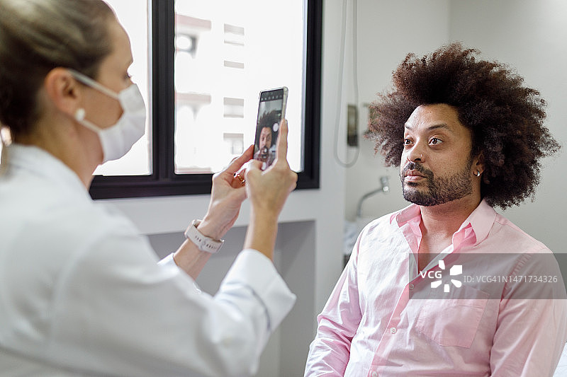 皮肤科医生正在拍摄男士治疗前后的照片图片素材