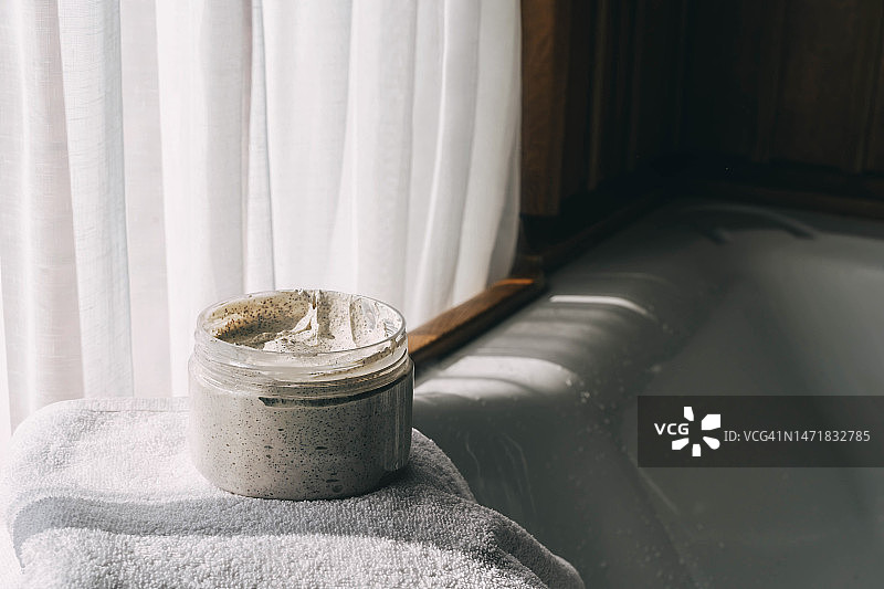 浴巾上的奶油或磨砂膏罐：身体护理和水疗理念图片素材