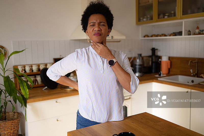 在家中喉咙不适的非裔美国女人图片素材