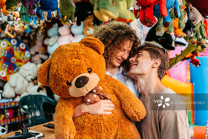 在射击游戏中，男友为女友赢得泰迪熊图片素材