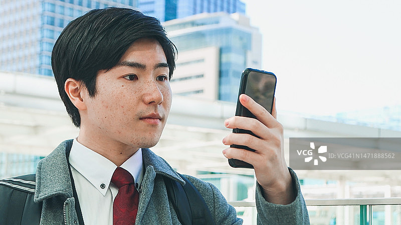 在户外使用手机的年轻商务男人图片素材