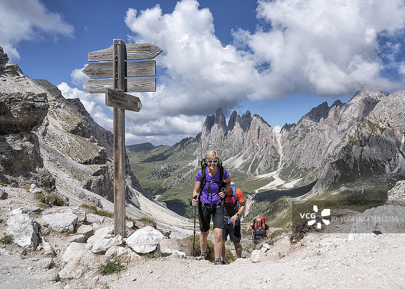 在意大利多洛米蒂山科尔达拉皮耶斯多云天空下徒步的男女图片素材