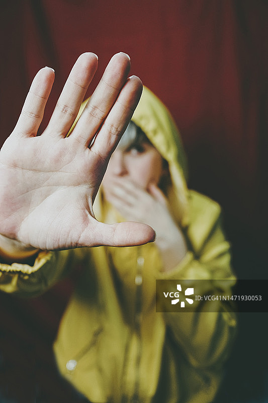 女人站在红色背景前做出停止手势图片素材