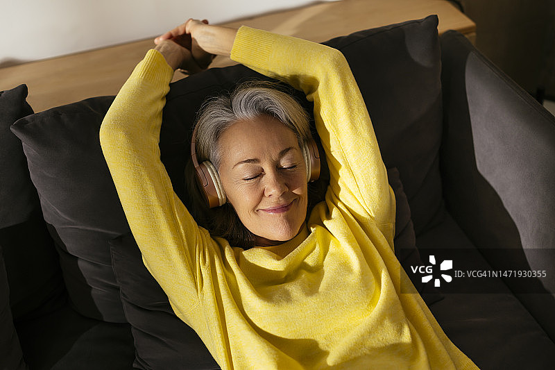 在家中沙发上放松的微笑女性图片素材