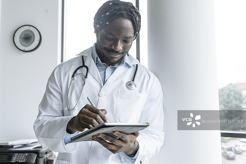 年轻医生在诊所使用平板电脑图片素材