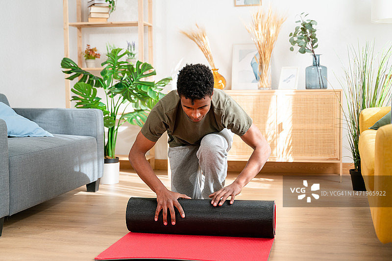 专注的非裔美国男子在舒适的客厅里做健身训练准备图片素材