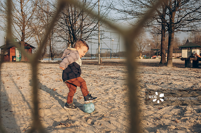 日落时分在沙地上玩球的儿童图片素材