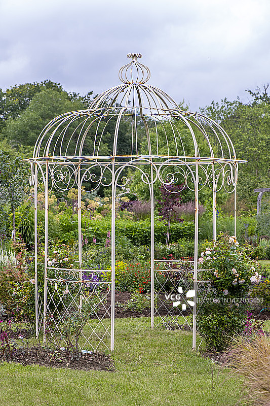 英式乡村花园中的白色铁制凉棚图片素材