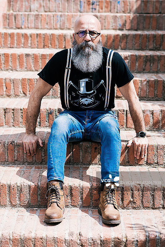 在公园里看着镜头的络腮胡时髦男人图片素材