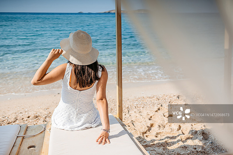 在沙滩的躺椅上晒日光浴的年轻女人图片素材