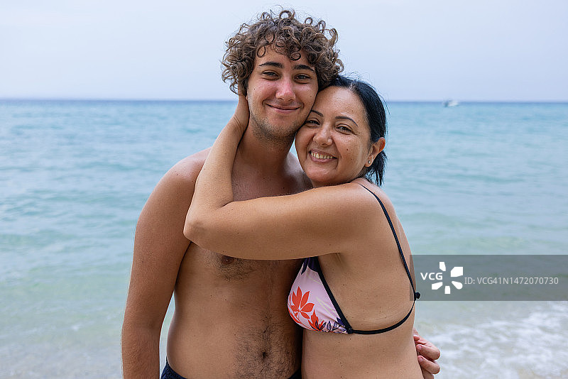 海滩上相拥的白人母子肖像图片素材